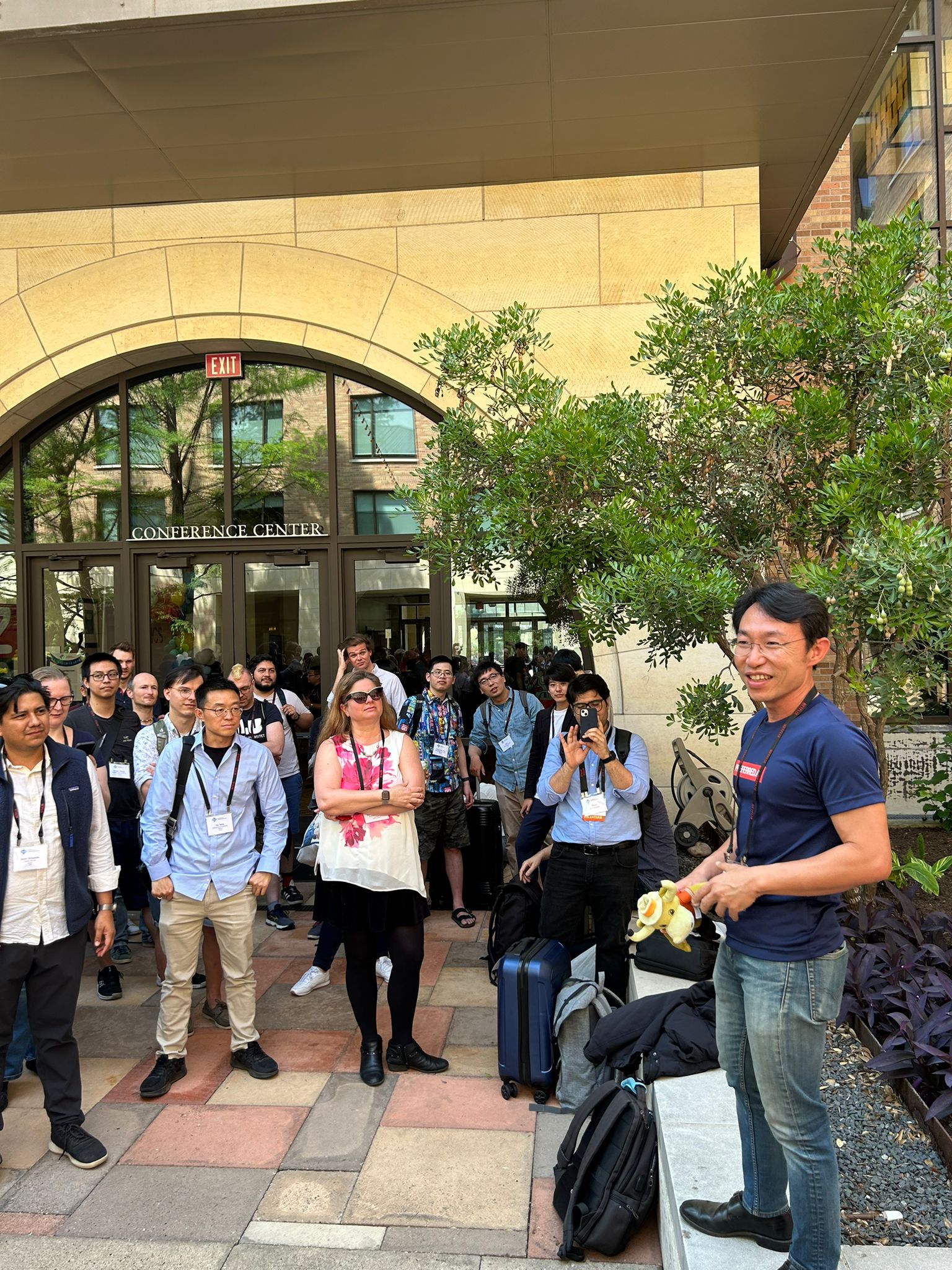 Hady making the pitch for 2024 at the lawn, while holding a Longhorn soft toy handed over by the 2023 conference chair Juan Sequeda